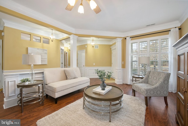 living room with a wainscoted wall, visible vents, ornate columns, and wood finished floors