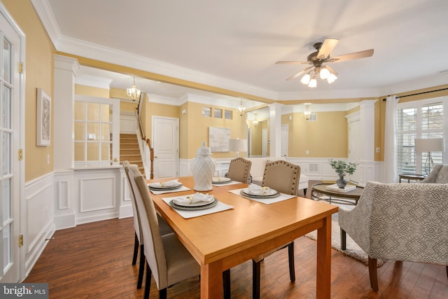 dining room with ceiling fan with notable chandelier, dark wood-style flooring, visible vents, stairs, and ornate columns