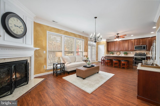 living room featuring dark wood-style floors, recessed lighting, visible vents, ornamental molding, and a high end fireplace