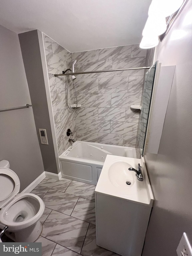 bathroom featuring toilet, marble finish floor, shower / bathing tub combination, baseboards, and vanity