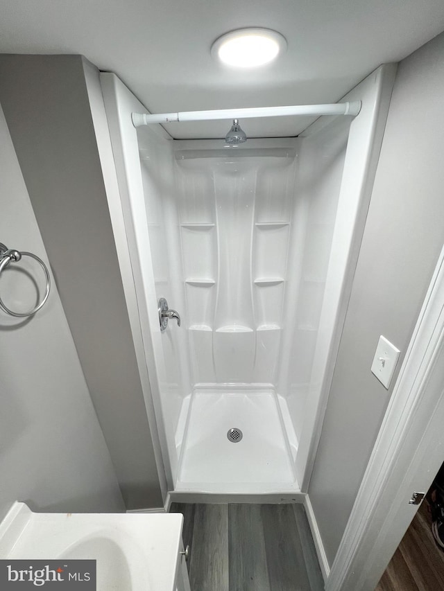 full bathroom with a shower stall and wood finished floors