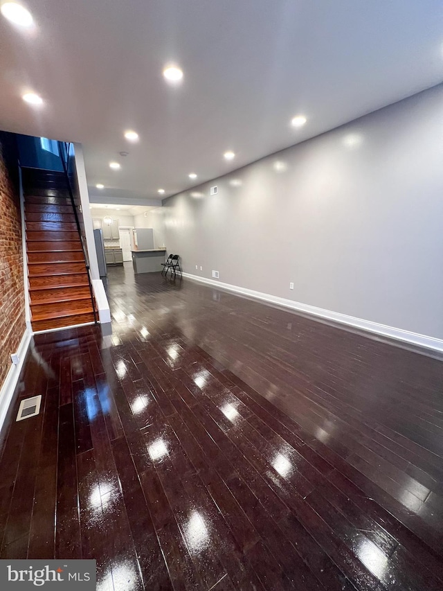 unfurnished room with visible vents, baseboards, stairs, recessed lighting, and dark wood-style flooring