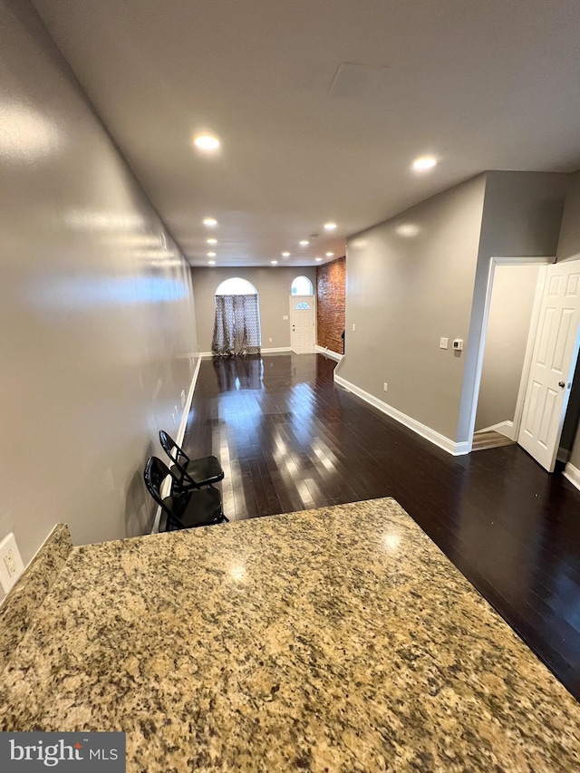 interior space featuring dark wood finished floors, recessed lighting, and baseboards