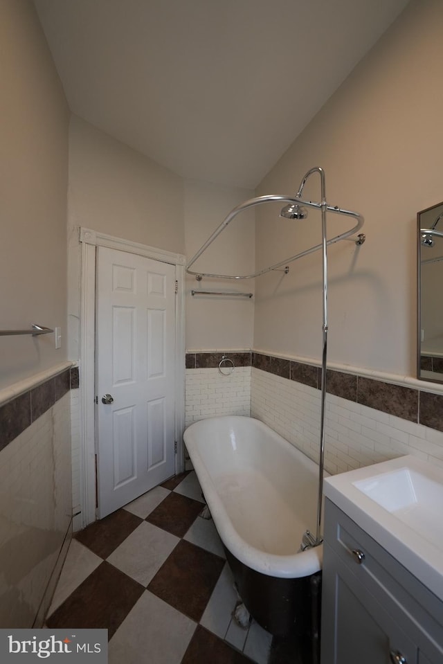 bathroom with vanity, tile walls, and a washtub