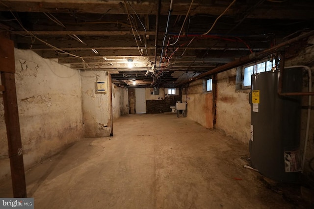 basement featuring a healthy amount of sunlight and water heater