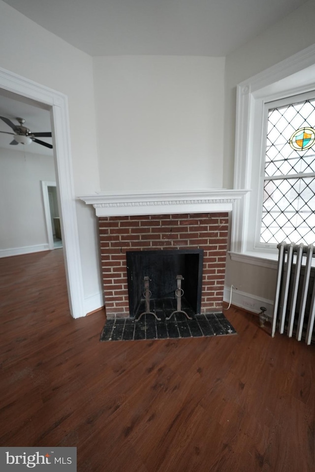 room details with wood-type flooring, radiator, ceiling fan, and a fireplace