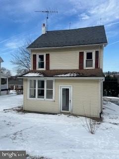 view of snow covered rear of property