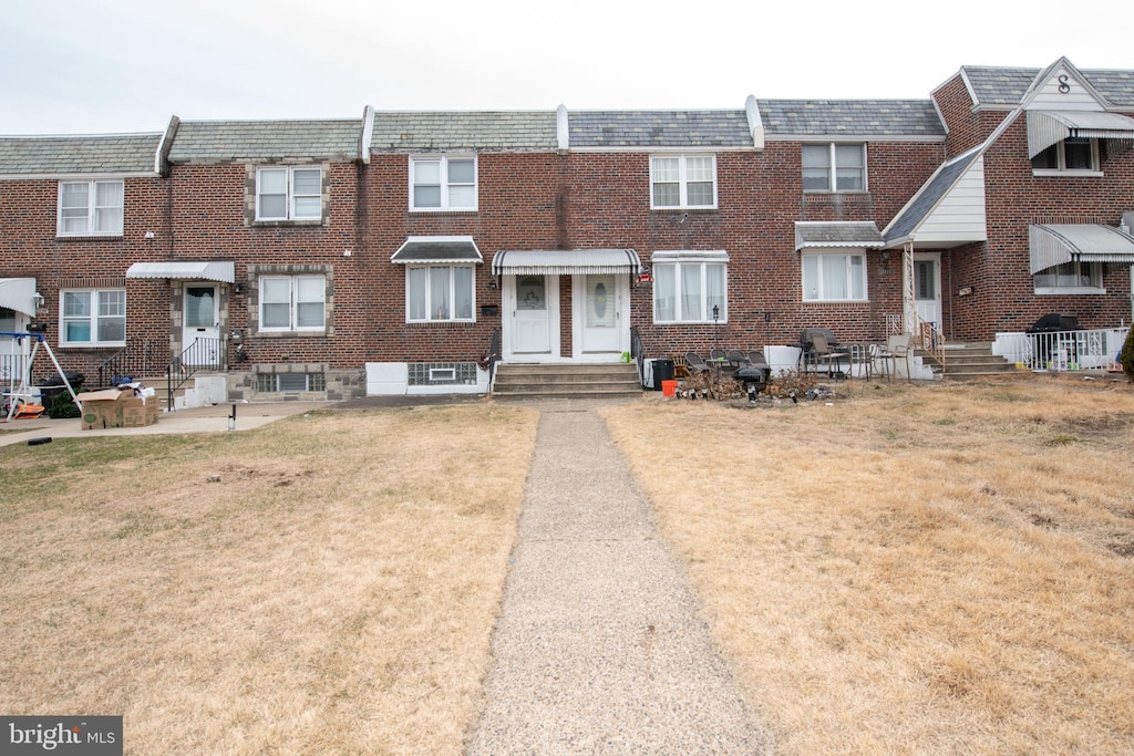 townhome / multi-family property featuring a front lawn