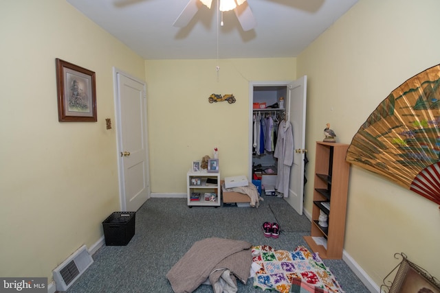 bedroom with dark colored carpet, ceiling fan, and a closet