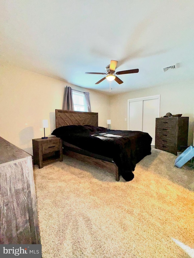 carpeted bedroom featuring a closet and ceiling fan