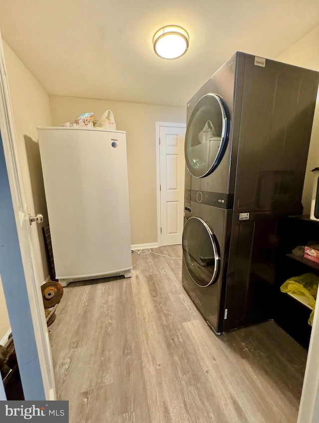 washroom featuring light wood-type flooring and stacked washer / dryer