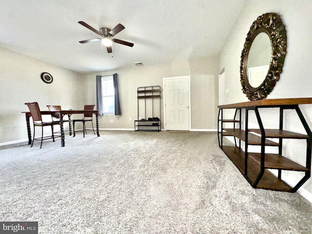 living area featuring carpet flooring and ceiling fan