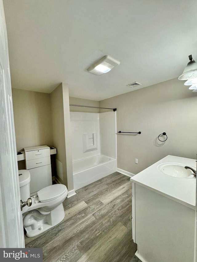 full bathroom featuring vanity, bathtub / shower combination, hardwood / wood-style floors, and toilet