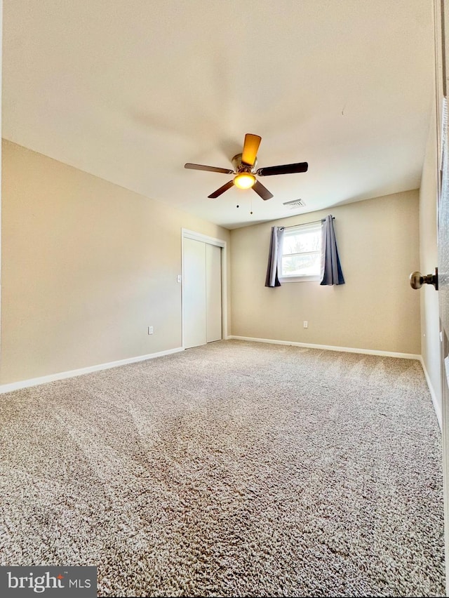 spare room featuring carpet and ceiling fan