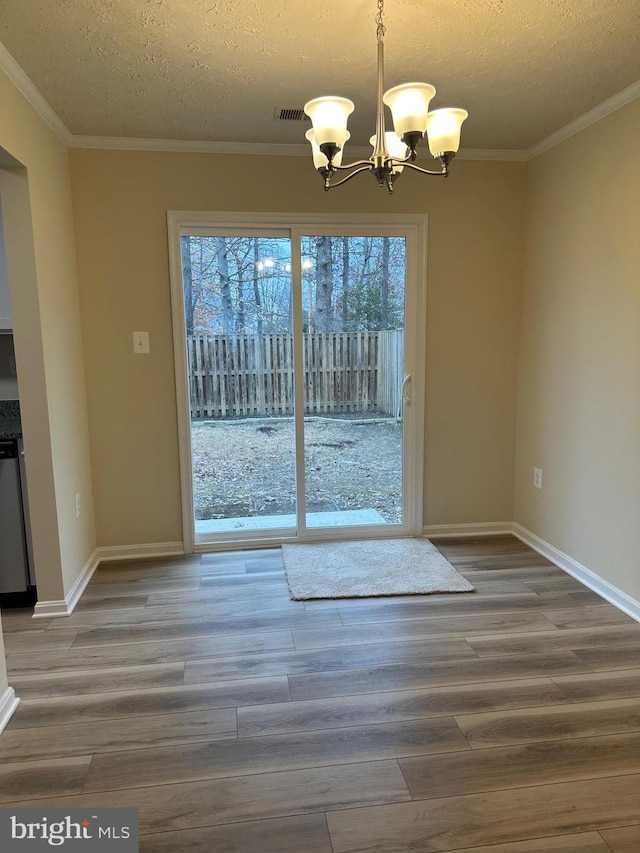 unfurnished dining area featuring hardwood / wood-style flooring, plenty of natural light, and a notable chandelier