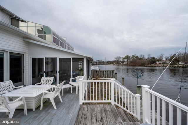 wooden deck featuring a water view and a sunroom