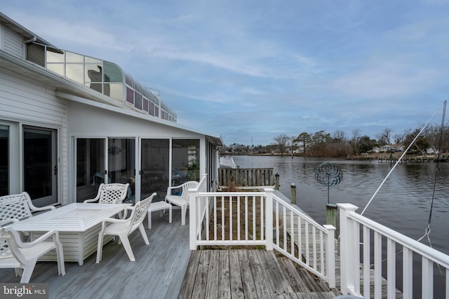 wooden deck with a water view and a sunroom