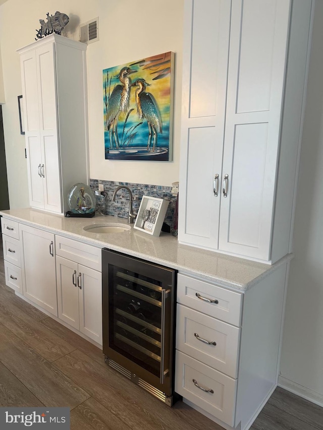 bar with wine cooler, dark hardwood / wood-style flooring, sink, and white cabinets