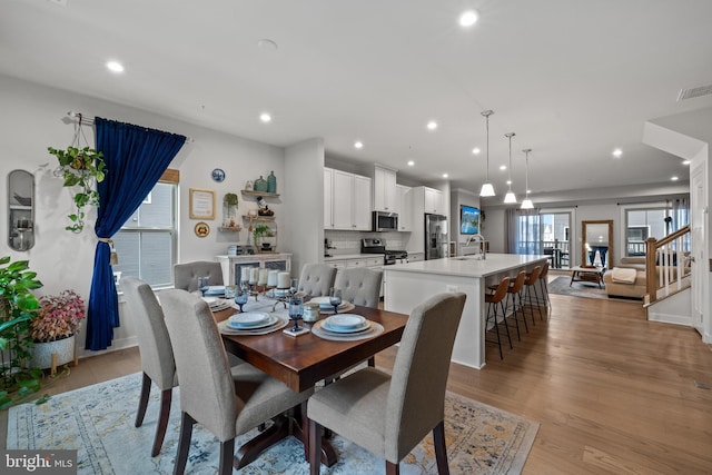 dining area featuring sink and light hardwood / wood-style flooring