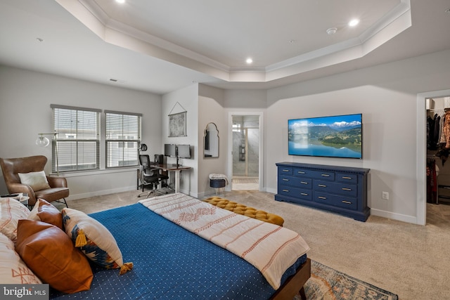 carpeted bedroom with connected bathroom, crown molding, a walk in closet, and a raised ceiling