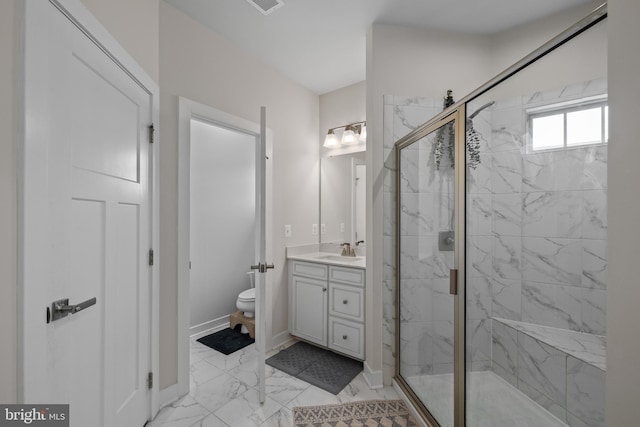 bathroom featuring vanity, a shower with shower door, and toilet