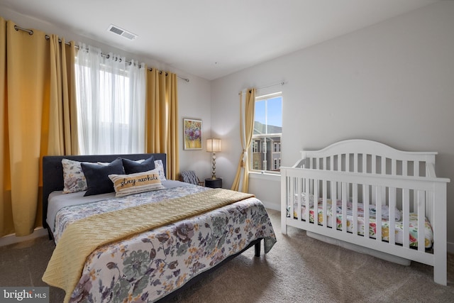 carpeted bedroom featuring multiple windows