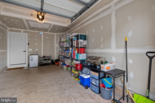 garage with white refrigerator and a garage door opener