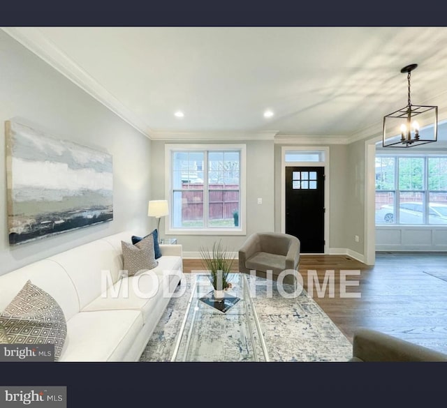 living room with hardwood / wood-style flooring, ornamental molding, and a chandelier