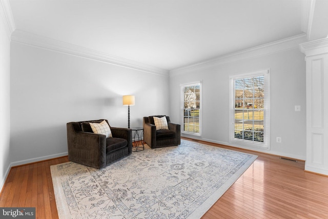 sitting room with crown molding and light wood-type flooring