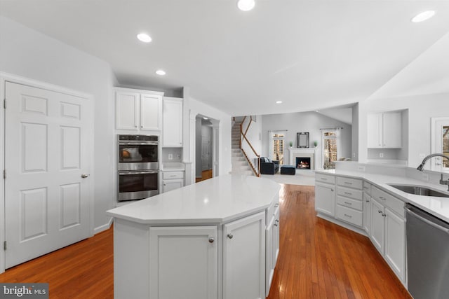 kitchen featuring white cabinetry, sink, wood-type flooring, and stainless steel appliances