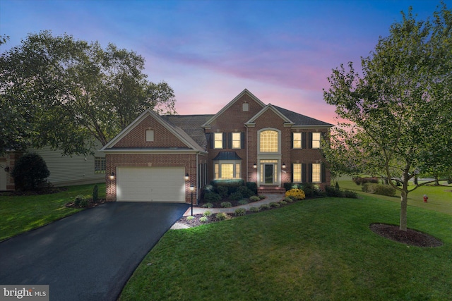 view of front of home featuring a garage and a yard