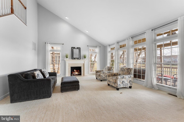 carpeted living room with high vaulted ceiling and a high end fireplace