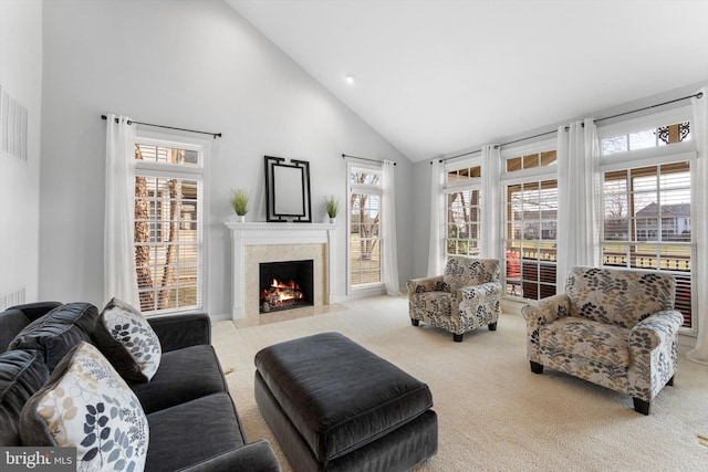 living room with a premium fireplace, light colored carpet, and high vaulted ceiling