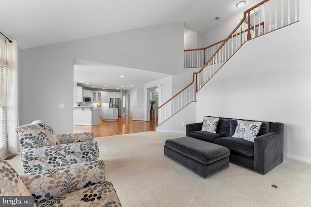 carpeted living room featuring high vaulted ceiling