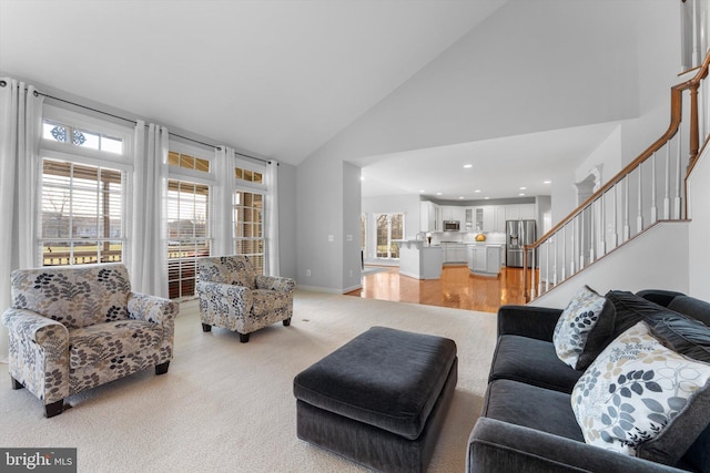 carpeted living room featuring high vaulted ceiling