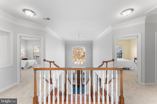 corridor featuring light carpet, a notable chandelier, and ornamental molding