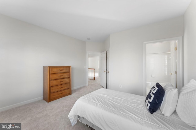 bedroom featuring light colored carpet and ensuite bath