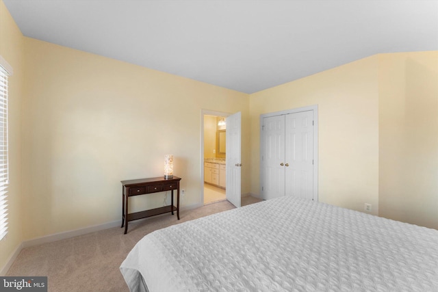 carpeted bedroom with ensuite bath and a closet