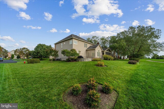 view of side of home with a yard