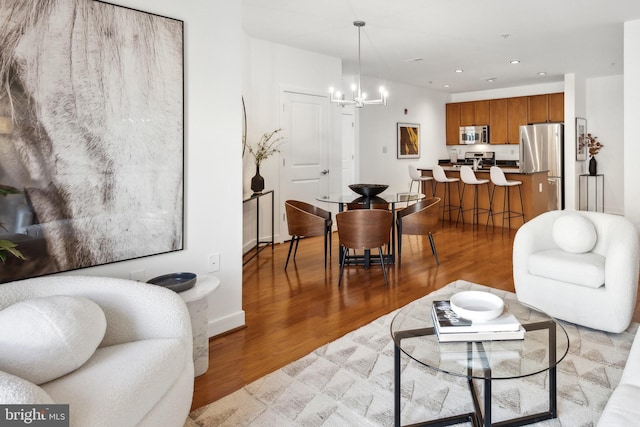 living room featuring an inviting chandelier and light wood-type flooring