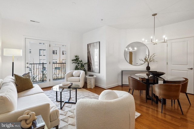 living room with an inviting chandelier and light wood-type flooring