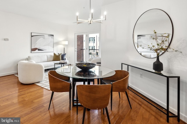 dining room with an inviting chandelier, hardwood / wood-style flooring, and french doors