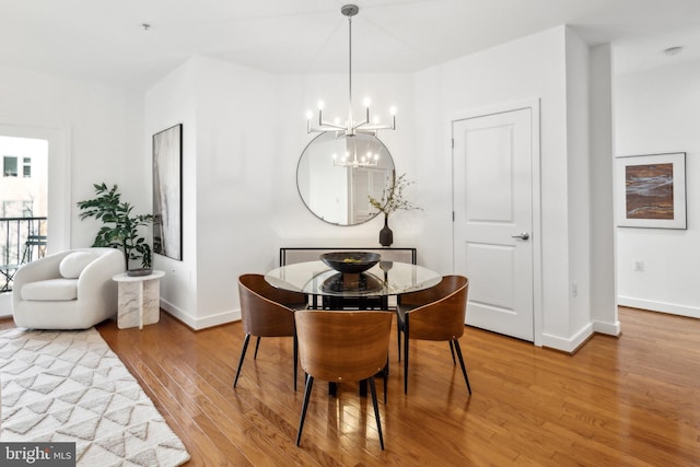 dining space with an inviting chandelier and hardwood / wood-style flooring