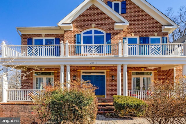 view of front facade with covered porch, french doors, a balcony, and ceiling fan