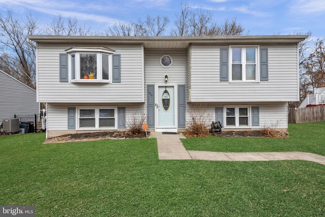 split foyer home with central AC unit and a front lawn