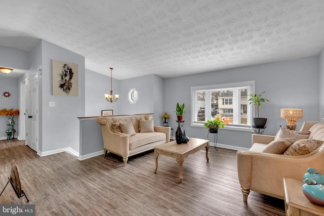 living room featuring an inviting chandelier, wood-type flooring, and a textured ceiling