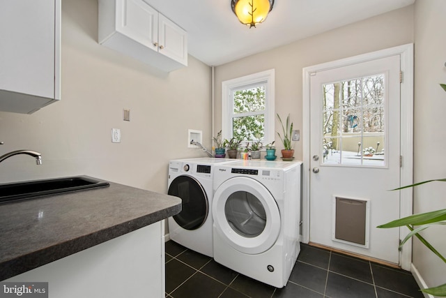 laundry area with independent washer and dryer, sink, cabinets, and dark tile patterned flooring