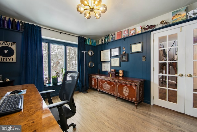 office space featuring french doors, a chandelier, and light wood-type flooring