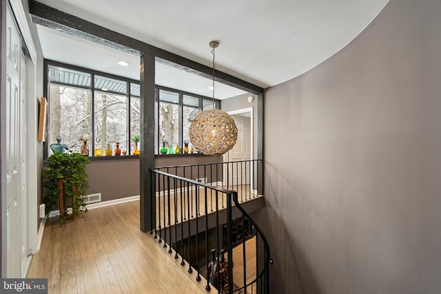 hallway with beamed ceiling, wood-type flooring, and a wealth of natural light