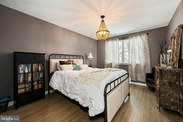 bedroom featuring hardwood / wood-style flooring and a chandelier